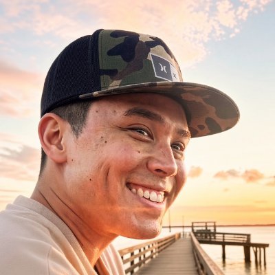 Nick, smiling on a dock over the river at sunset